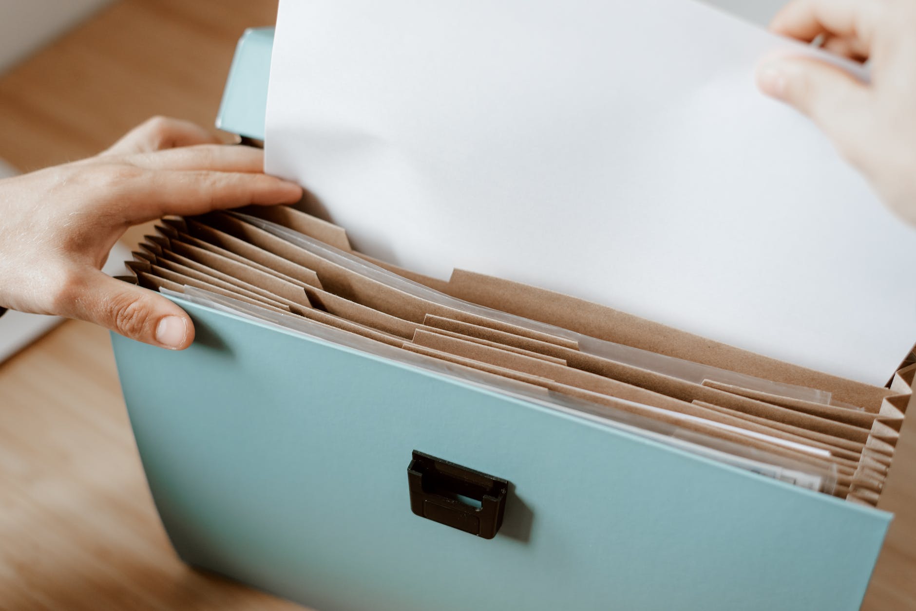 person taking white paper from folder