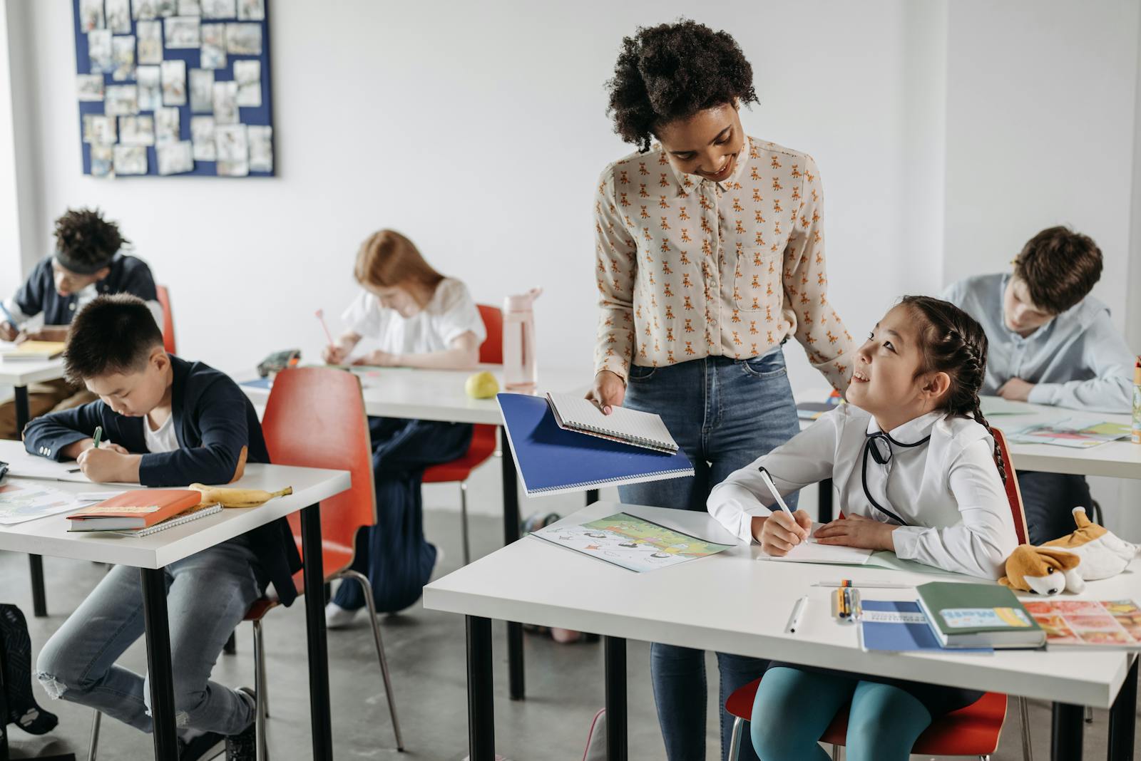 A diverse group of students engaged in learning with a teacher's guidance in a classroom setting.